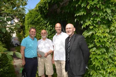 Dezernent Dr. Harald Sempf (r.) und Kreishandwerksmeister Michael Ziesecke (l.) gratulieren Marco und Petro Mett zum 40-jährigen Betriebsjubiläum.