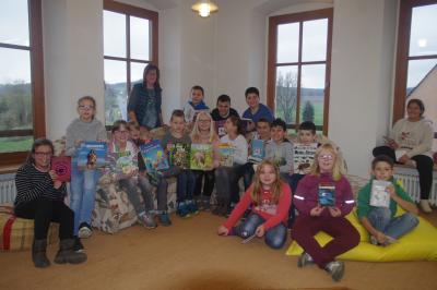 Die Kinder der 4. Klasse der Grundschule Röslau zeigen ihre gerade ausgeliehenen Bücher. Mit auf dem Bild Frau Claudia Gebhardt, die ehrenamtlich die Ortsbücherei verwaltet.