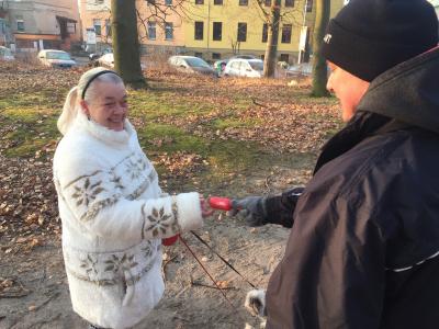 Außendienstmitarbeiter Ronny Köhler verteilt an eine Hundebesitzerin einen der Müllbeutelspender