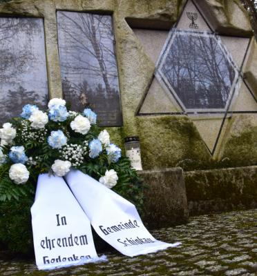 Blumen und eine Kerze für die Opfer des Verlorenen Transports bei Schipkau