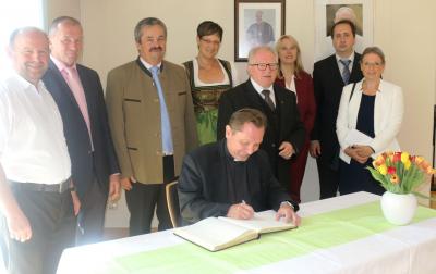 Foto zur Meldung: Domkapitular Dr. Roland Batz trägt sich in das Ehrenbuch der Gemeinde Miltach ein