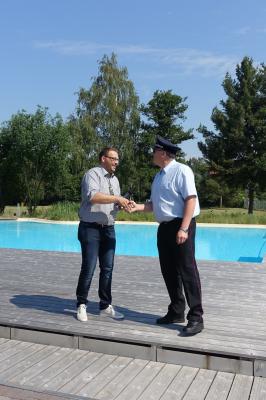 Samtgemeindebürgermeister Gero Janze (l.) übergibt die Ausweise zur kostenlosen Nutzung des Bades an Gemeindebrandmeister Maik Wermuth (r.).