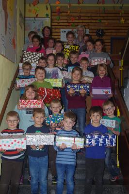 Unser Foto zeigt die Kinder mit liebevoll gestalteten Päckchen sowie die Kindergarten-Leiterin Elisabeth Nickl und die Rektorin der Schule Annelies Rogler-Unglaub.