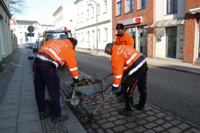 Drei Mitarbeiter der Firma Bartsch reinigen im Auftrag der Stadt die Parktaschen in der Gartenstraße.