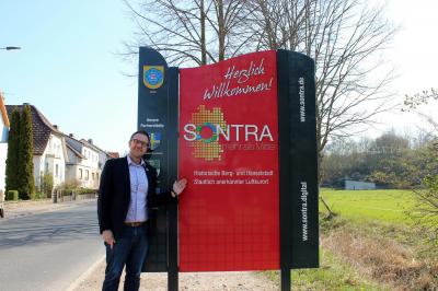 Bürgermeister Thomas Eckhardt präsentiert die neue Ortseingangstafel in der Fuldaer Straße. (Bild vergrößern)