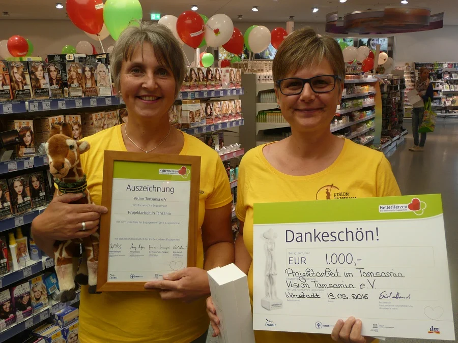 Tatjana Reis zeigt Auszeichnung und Sabine Schwarz den Scheck