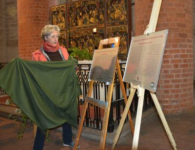 Christine Flassig, Mitglied des Gemeindekirchenrates, enthüllt die zwei Tafeln. Foto: Hans-Werner-Boddin