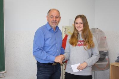 Schulleiter Uwe Schwanz dankt der Schülerin Helena für ihr Umweltengagement (Bild vergrößern)