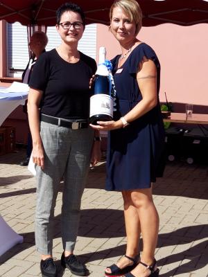 Stadt Perleberg | Bürgermeisterin Jura brachte Perleberger Sekfflasche als Geschenk mit und überreichte diese Mandy Linow, Leiterin der Eingliederungshilfe der AWO Prignitz.