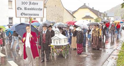 Sie hatten die Rundkirche vom Enchesberg ins Dorf geholt, und der Bürgermeister höchstpersönlich zog die „Miniausführung“ durch den Ort. Foto: Kahl (Bild vergrößern)