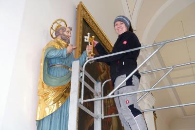 Foto zu Meldung: Tanja Preuß vergoldet einen der Petrusschlüssel und stellt somit die Richtigkeit der Ikonographie in der Pfarrkirche St. Georg Prackenbach her
