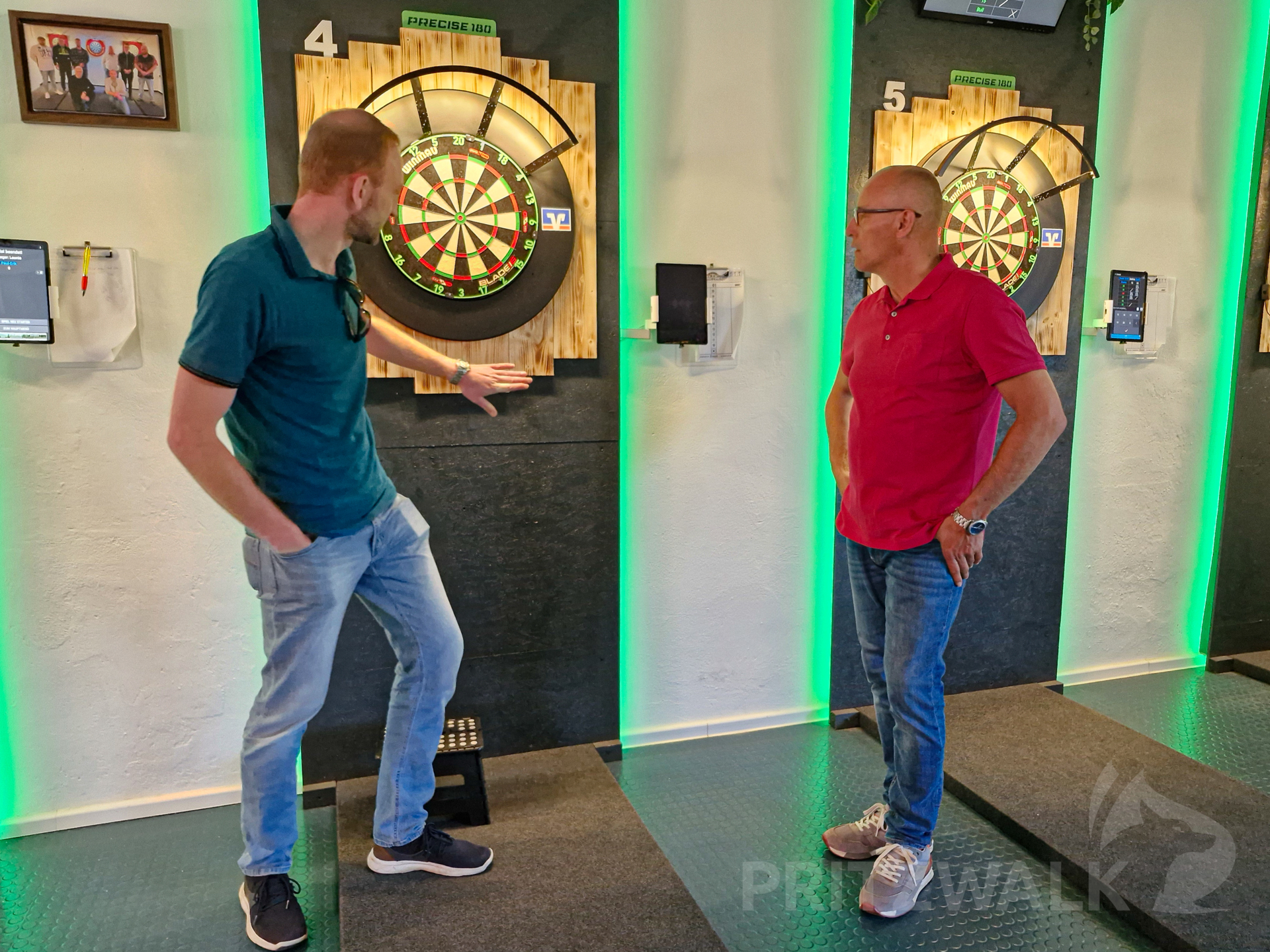 Vereinschef Tino Gutsche erklärt Bürgermeister Dr. Ronald Thiel die Dartboardanlage.