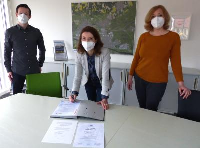 In Anwesenheit der beiden Klimamanager Dimitri Militschenko und Nina Stiehr (rechts) unterzeichnet Bürgermeisterin Monika Böttcher die Charta „Hessen aktiv: Die Klima-Kommunen“. Foto: Stadt Maintal