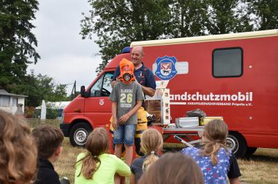 Stadt Perleberg | Brandschutzfachwart R. Arnold führt den Kids die Atemmaske vor.