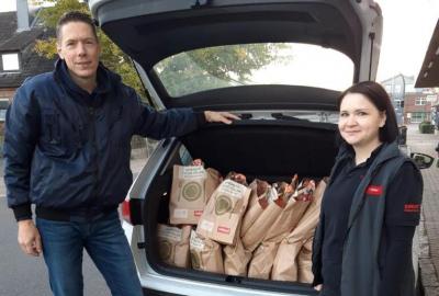Yvonne Scharf vom Nahkauf-Markt übergibt die Spendentüten an Torben Ahmling von der Tafel Itzehoe