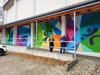 Katharina Kaireit und Patrick Bräutigam freuen sich über die neue Wandgestaltung an der Quandt-Sporthalle. Foto: Beate Vogel