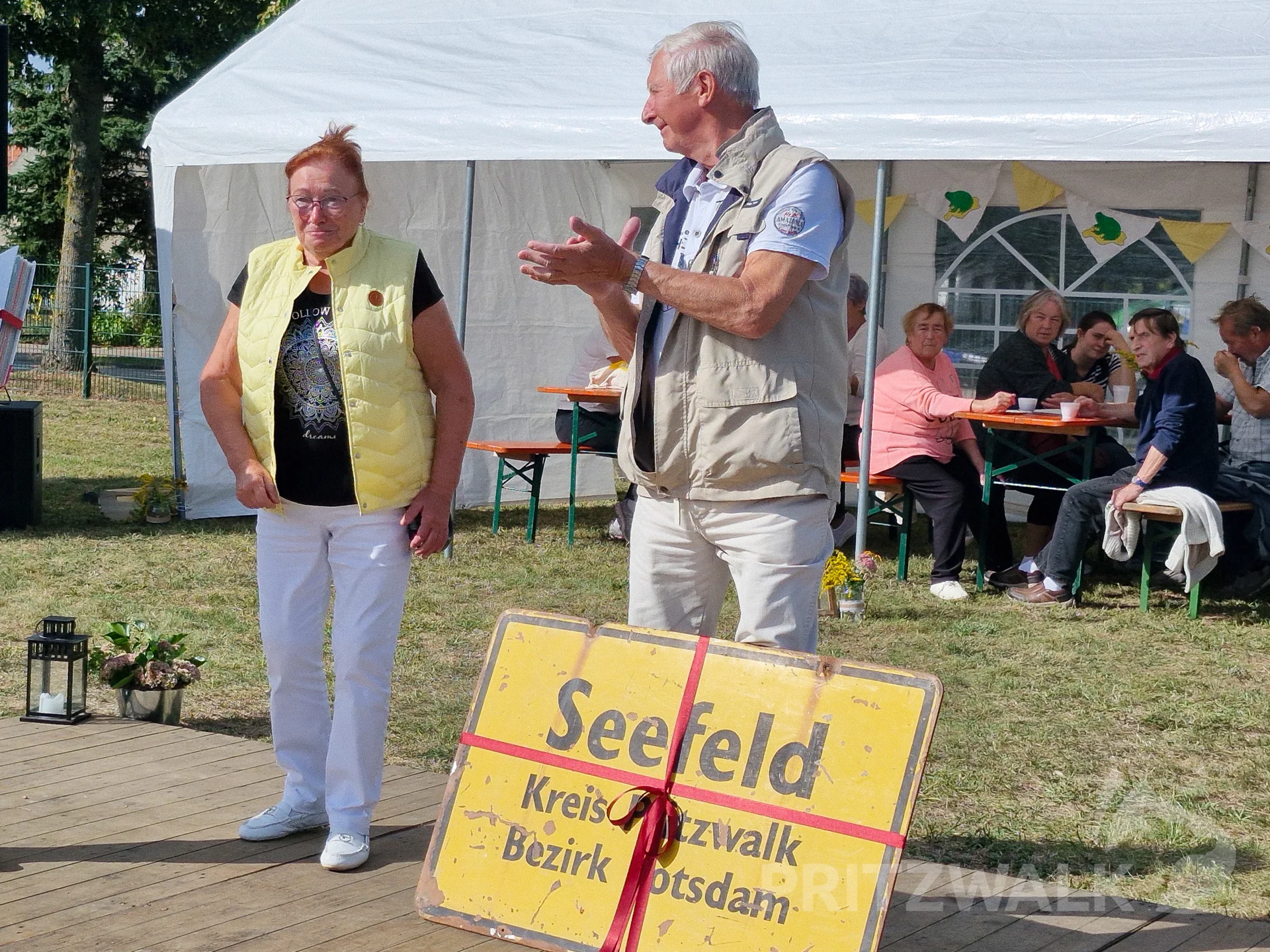 Zum Programm auf der Bühne in der Mitte von Kuchenbuffet, Festzelten und Tresen gehörte die Übergabe eines alten Seefelder Ortschildes. Foto: Stadt Pritzwalk