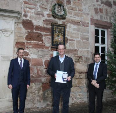 Bildunterschrift: Landrat Stefan Reuß erhielt die Auszeichnung aus den Händen des Geschäftsführende HLT-Direktors Prof. Dr. habil. Jan Hilligardt (r.) und des HLT-Direktors Dr. Michael Koch (l.). (Bild vergrößern)