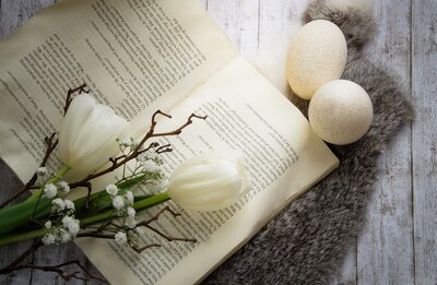 Symbolbild: Buch mit Tulpen und Osterdeko von Ylanite auf Pixabay