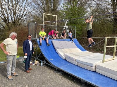 Bürgermeister Lars Obermann bestaunt die von den Kindern mit Unterstützung von Klaus Kiwi erbaute Seilbrücke über die Skateboardanlage.