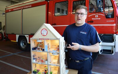 Domenik Weitzmann, Fachwart für Brandschutzerziehung und Ortsjugendwart der Feuerwehr Wittenberge zeigt das neue Demo-Rauchhaus I Foto: Martin Ferch