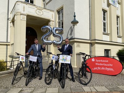 Übergabe der zwei E-Bikes von der Sparkasse durch Marcus Starick an Landrat Heinze und Präsentation der fünf Hauptgewinne der 25. Tour de OSL (Foto: Landkreis OSL / Nora Bielitz) (Bild vergrößern)