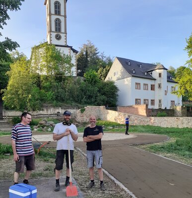 Foto zur Meldung: Ehrenamtliche Helfer stellen Wege vom Dorfplatz fertig