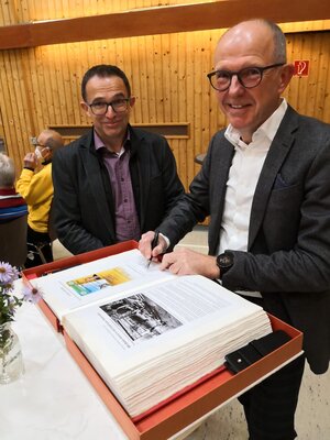 Bürgermeister Obermann neben Stefan Arend, der sich im Gästebuch der Stadt Immenhausen einträgt