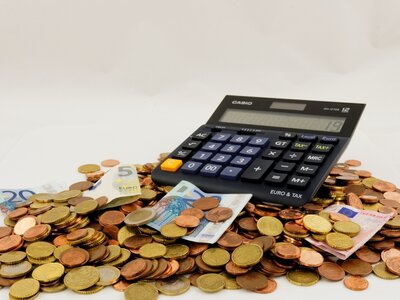 Taschenrechner liegt auf Geldscheinen und Münzen (c) pixabay