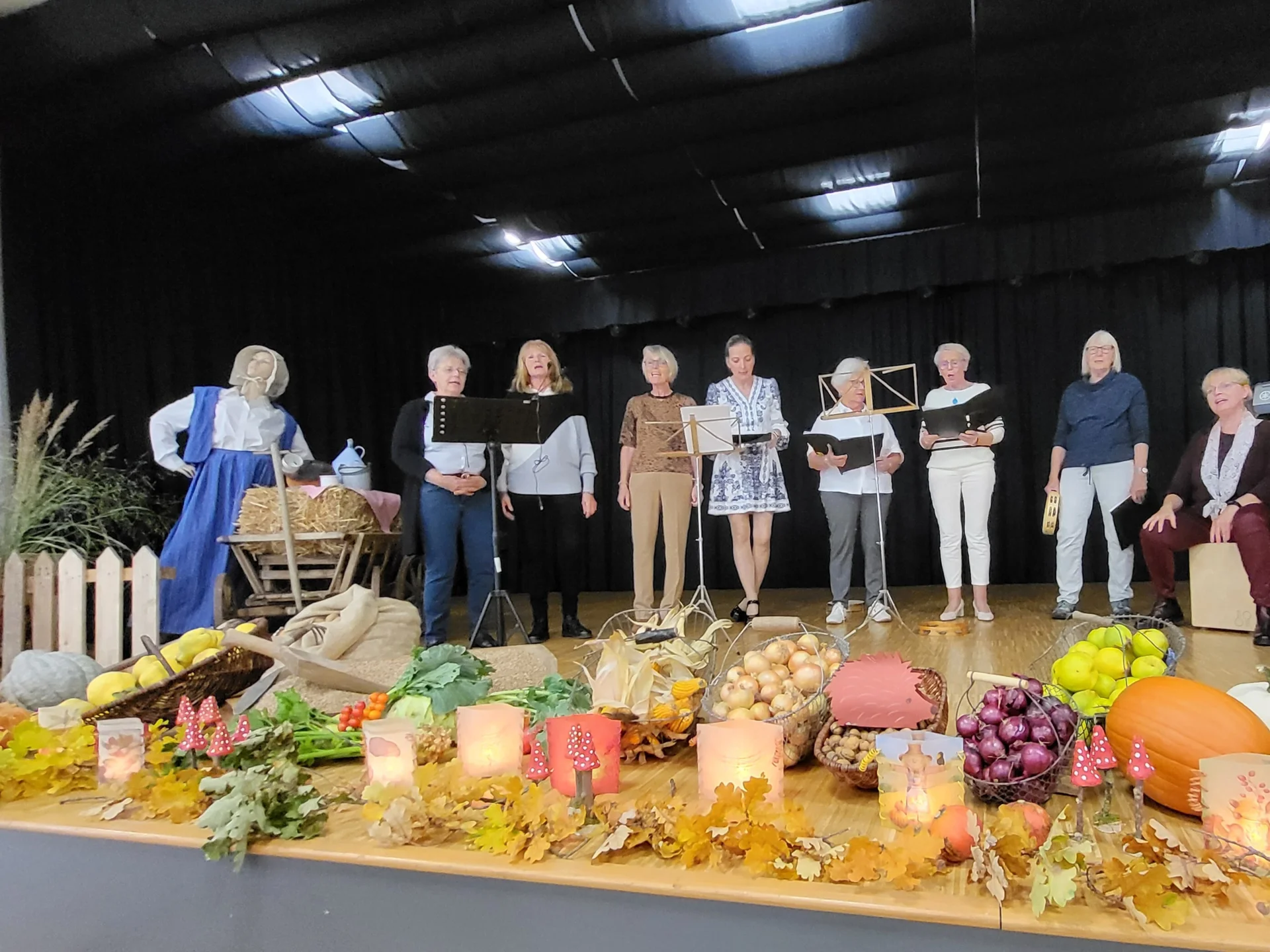 8 Frauen singen auf der Bühne etwas vor