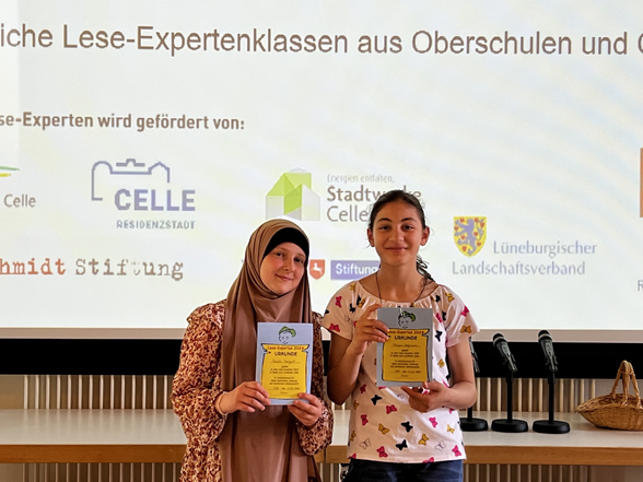 Rayan Zaghnoun, Klasse 6b (rechts im Bild) und ihre Mitschülerin bei der Ehrung der Lese-Experten