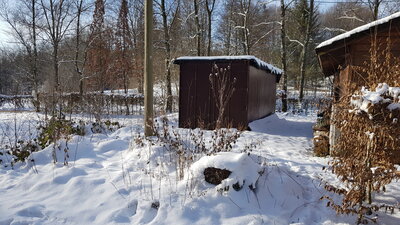 Geräte-Container, der mit einer Wildsträucher-Hecke umgeben wird