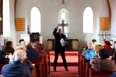Pfarrer Frank Grützmann gibt Erklärungen zur Geschichte der Dorfkirche Hönow.