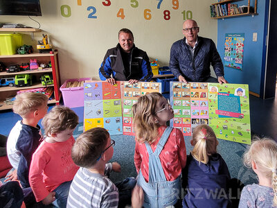 Metallbauer Robert Wüst und Bürgermeister Dr. Ronald Thiel präsentieren den Kindern der Villa Berti die Bücher. Foto: Beate Vogel