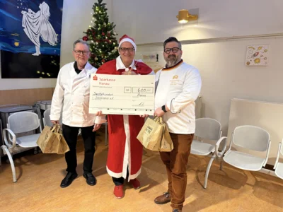 Ehrenobermeister Rudi Bär und der stellvertretende Obermeister Jochen Kolb übergeben einen Scheck über 600 Euro an Oberarzt Dr. Bungert. Dieser trägt ein Nikolaus-Kostüm. (Bild vergr&ouml;&szlig;ern)