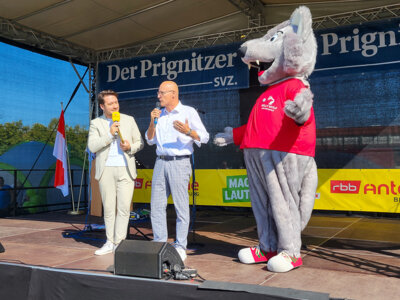 Auf der Festbühne warb der Pritzwalker Bürgermeister mit dem Mas-kottchen Willy Wolf für Pritzwalk. Moderiert hatte RBB-Moderator Christofer Hameister. Foto: Beate Vogel