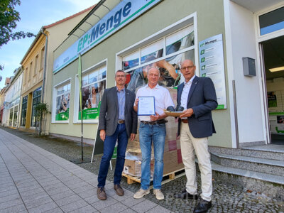 Tristan Menge (Mitte) ist seit 25 Jahren in der Marktstraße für seine Kunden da. Bürgermeister Dr. Ronald Thiel und René Georgius von der IHK gratulieren. Foto: Beate Vogel