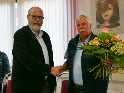 Der Amtsausschussvorsitzende Uwe Kessler beglückwünscht den wiedergewählten Amtsdirektor Hergen Reker