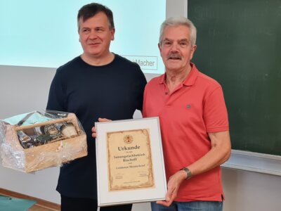 Schuhmachermeister Horst Bischoff erhält von Obermeister Arno Carius eine Urkunde sowie einen Präsentkorb zur Auszeichnung seines Goldenen Meisterbriefes