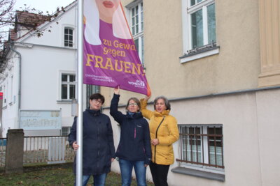 Unser Bild zeigt SVV-Vorsitzende Julia Concu, Gleichstellungsbeauftragte Juliane Wutta und Landtagsvizepräsidentin Barbara Richstein bei der Flaggenhissung 2022 vor dem Falkenseer Rathaus.