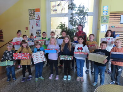 Unser Foto zeigt Kinder mit liebevoll gestalteten Päckchen und die Rektorin der Schule Annelies Rogler-Unglaub. (Bild vergrößern)
