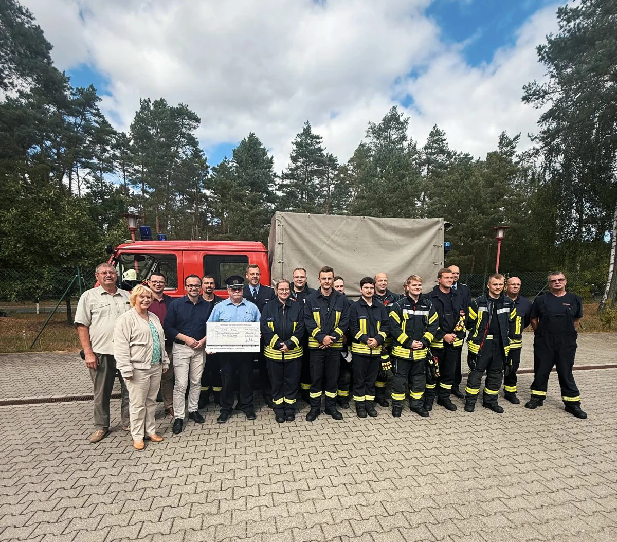 Innenminister Dr. Jan Redmann mit Gästen und Feuerwehrleuten bei der Übergabe.