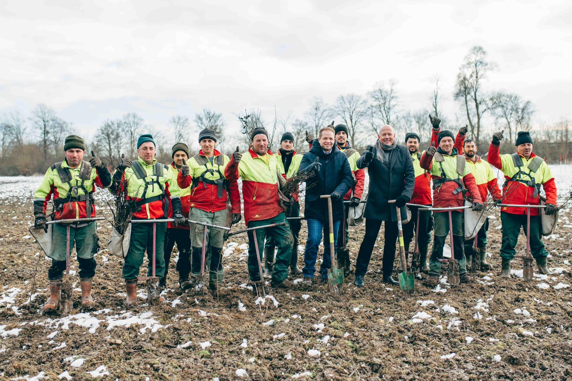 Umweltdezernent Uwe Zaar und Landrat Frank Rock stehen mit dem Pflanztrupp der Firma VitaForst vor neu gepflanzten Bäumen