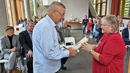 Silvia Zimmermann vom Kultur- und Heimatverein Ziesar überreicht Pritzerbes Ortsvorsteher Klaus Meyer eine Kerze mit dem Pritzerber Stadtwappen. © Quelle: Frank Bürstenbinder
