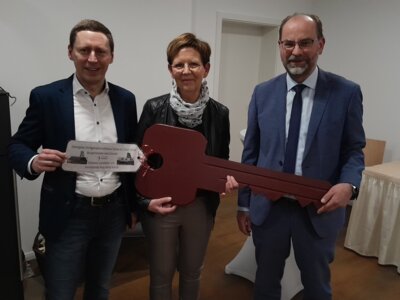 Foto: Rolandstadt Perleberg | Bürgermeister Axel Schmidt (links) und Michael Brentrup übergeben den symbolischen Schlüssel an Petra Schulz.