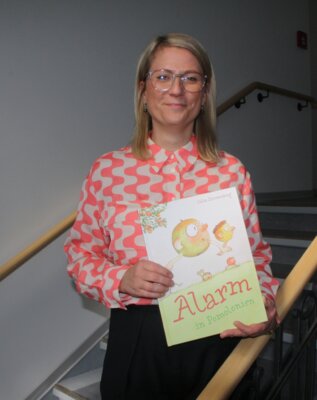 Landrätin Nicole Rathgeber mit einem Exemplar von „Alarm in Pomolonien“ (Bild vergrößern)