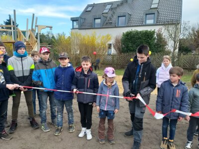 Foto: Rolandstadt Perleberg | Kinder aus der Waldsiedlung durchschneiden das symbolische Band zur Freigabe ihres neuen Spielplatzes.