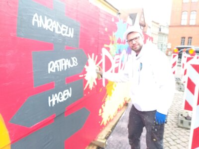 Foto: Rolandstadt Perleberg | Björn Jensen gestaltet den Bauzaun mit Graffiti. Fürs Foto hat er die Schutzmaske kurz abgenommen.