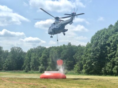 Foto: (Archiv) Landkreis Oberhavel / Ivonne Pelz - ein Hubschrauber nimmt Löschwasser im Flug auf