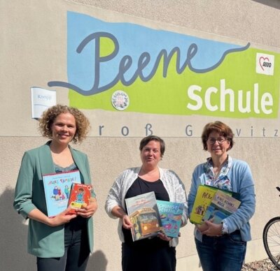 Karolin Gramß, Sara Kokemüller (Landesfrauenrat MV) und Anke Dörner (Peeneschule) präsentieren vielfältige Bücher